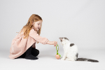 een meisje speelt met een kat met de sisalbal een meisje speelt met een kat met de sisalbal